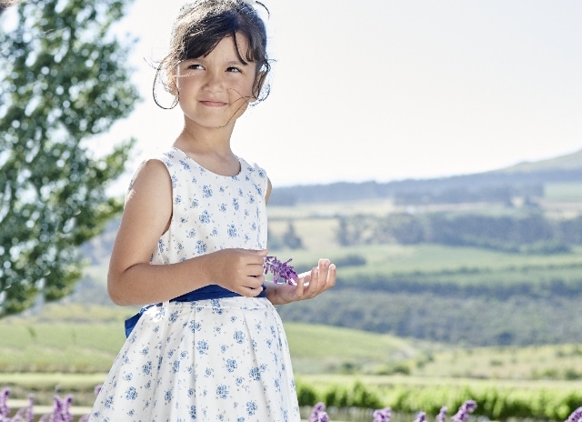 Ein Mädchen in einem weißen und blauem Festkleid