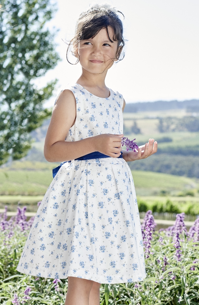 Ein Mädchen in einem weißen und blauem Festkleid